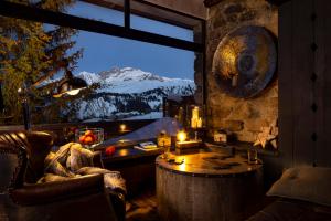 een kamer met een tafel en uitzicht op een berg bij Hôtel Courcheneige in Courchevel