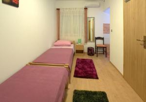 um quarto com duas camas e uma cadeira e uma janela em Rooms by the sea Zadar - 18319 em Zadar
