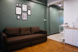 T3 TWO Bedrooms WIFI Full kitchen 1 min to BTS في بانكوك: أريكة في غرفة مع جدار أخضر