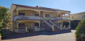 une grande maison jaune avec deux balcons. dans l'établissement Apartments with a parking space Vir - 18407, à Vir