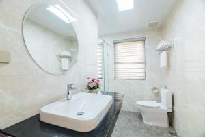 下龙湾Jade Ha Long Hotel的浴室里有洗手池、马桶和镜子。 更多86张照片