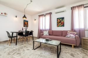 un soggiorno con divano e tavolo di Apartments by the sea Mali Losinj, Losinj - 18406 a Mali Lošinj (Lussinpiccolo)
