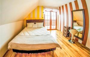 a bedroom with a large bed and a mirror at Lovely Home In Malechowo With Wifi in Malechowo