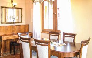 a dining room with a table and chairs and a mirror at Amazing Home In Malechowo With 3 Bedrooms, Wifi And Outdoor Swimming Pool in Malechowo