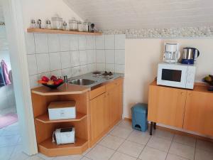 eine kleine Küche mit einer Spüle und einer Mikrowelle in der Unterkunft Apartments with a parking space Crikvenica - 18410 in Crikvenica