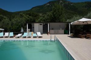 una piscina con sillas y sombrilla en Villa Cerasiello, en Bracigliano