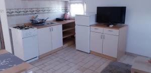 a kitchen with white cabinets and a flat screen tv at Apartments by the sea Nevidjane, Pasman - 18427 in Neviđane +16 photos