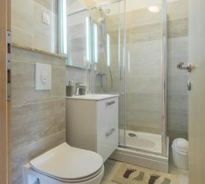 łazienka z toaletą i prysznicem w obiekcie Apartments by the sea Simuni, Pag - 18386 w mieście Kolan +30 zdjęć