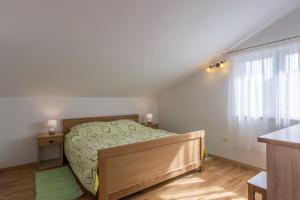 mała sypialnia z łóżkiem i oknem w obiekcie Apartments by the sea Simuni, Pag - 18386 w mieście Kolan