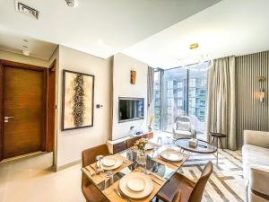 a living room with a dining table and a couch at STAY BY LATINEM Luxury 1BR Holiday Home CV A2604 near Burj Khalifa in Dubai