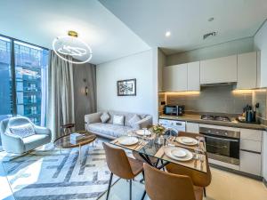 een keuken en een woonkamer met een tafel en stoelen bij STAY BY LATINEM Luxury 1BR Holiday Home CV A2604 near Burj Khalifa in Dubai