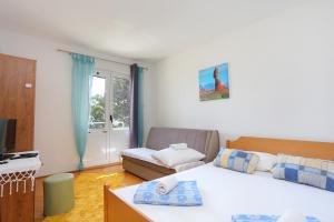a small bedroom with a bed and a couch at Apartments by the sea Zivogosce - Porat, Makarska - 18218 in Igrane