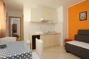 eine Küche und ein Esszimmer mit einem Tisch und einer Küche gmaxwell gmaxwell gmaxwell gmaxwell in der Unterkunft Apartments by the sea Zivogosce - Porat, Makarska - 18218 in Igrane