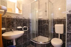 ein Badezimmer mit Dusche, Toilette und Waschbecken in der Unterkunft Apartments by the sea Zivogosce - Porat, Makarska - 18218 in Igrane