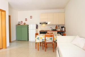 een keuken met een tafel en stoelen en een koelkast bij Apartments with a parking space Seget Vranjica, Trogir - 18326 in Donji Seget