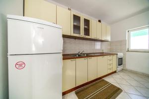 a kitchen with a white refrigerator and a sink at Apartments with parking space Postira, Brac - 18472 in Postira +8 photos