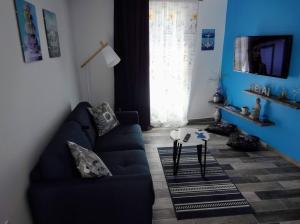 niebieski salon z kanapą i stołem w obiekcie Apartments by the sea Sibenik - 18501 w Szybeniku