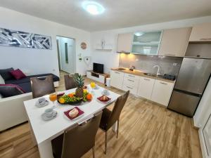 a kitchen and dining room with a table with fruit on it at Apartments by the sea Slatine, Ciovo - 18481 in Slatine