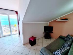 a living room with a couch and a television at Apartments by the sea Slatine, Ciovo - 18481 in Slatine