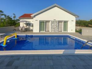 a swimming pool in front of a house at Seaside luxury villa with a swimming pool Privlaka, Zadar - 18508 in Privlaka