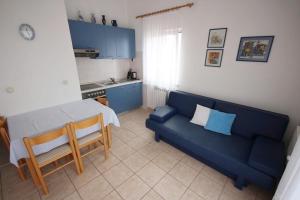 salon z niebieską kanapą i kuchnią w obiekcie Apartments by the sea Vir - 18514 w mieście Vir +11 zdjęć