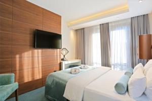 a hotel room with a bed and a flat screen tv at Rooms with a swimming pool Split - 18489 in Split