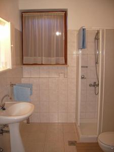 uma casa de banho com um chuveiro e um lavatório. em Apartments for families with children Vinez, Labin - 18493 em Labin