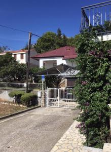 biały płot przed domem z krzakiem w obiekcie Apartments with a parking space Starigrad, Paklenica - 18492 w mieście Starigrad-Paklenica