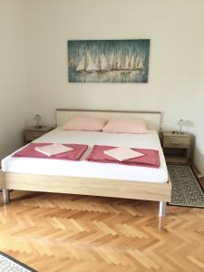 łóżko z różowymi poduszkami i obrazem na ścianie w obiekcie Apartments with a parking space Starigrad, Paklenica - 18492 w mieście Starigrad-Paklenica