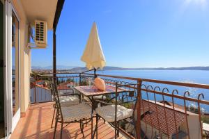 een balkon met een tafel en stoelen en de oceaan bij Apartments by the sea Seget Donji, Trogir - 18488 in Trogir