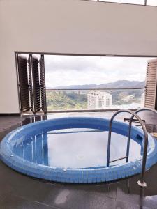 a hot tub in a room with a large window at Mossy Forest Family Retreat, Kea Farm Brinchang in Brinchang