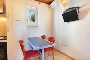 eine kleine Küche mit einem Tisch und einem Kühlschrank in der Unterkunft Apartments with a parking space Brela, Makarska - 18495 in Brela