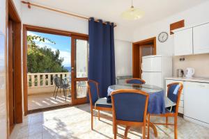 eine Küche mit einem Tisch und Stühlen sowie einen Balkon in der Unterkunft Apartments with a parking space Brela, Makarska - 18495 in Brela