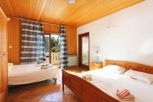 2 Betten in einem Zimmer mit Holzwänden und Holzböden in der Unterkunft Apartments with a parking space Brela, Makarska - 18495 in Brela