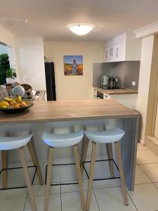 a kitchen with a wooden counter with two bar stools at Aloomba Oasis in Ross River