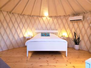 um quarto com uma cama branca numa tenda em Moonlight Suite Arad צימר אור הירח, ערד em Arad
