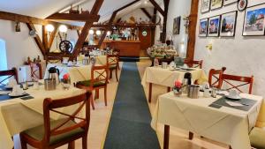 una sala da pranzo con tavoli e sedie con tovaglie bianche di Landhaus Kyritz a Kyritz