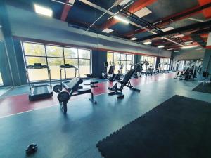 a gym with several treadmills and cardio machines at Lankaran Olimpiya Hotel in Lankaran