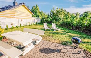 a picnic table and a grill in a yard at 2 Bedroom Cozy Home In Dabki in Dąbki