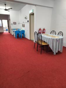 a room with a table and chairs and red carpet at WORLD KIDS FANTASY in Lumut