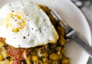 a plate of food with an egg on top of food at Cantinho C - Alojamento Complementar in Praia