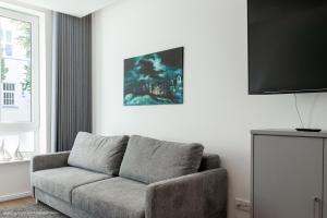 a living room with a couch and a flat screen tv at LIGHTHOUSE APPARTEMENTS in Warnemünde