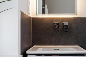 a bathroom with a sink and a mirror at LIGHTHOUSE APPARTEMENTS in Warnemünde