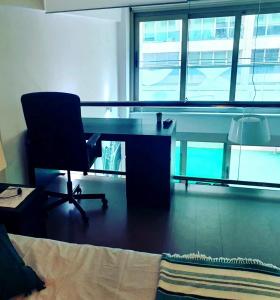 um escritório com uma secretária, uma cadeira e janelas em DUPLEX 2 PLANTAS - c ALCALA-IFEMA-VENTAS- JARDIN & PARKING PRIVADOS- SUITES BOUTIQUE WH em Madri