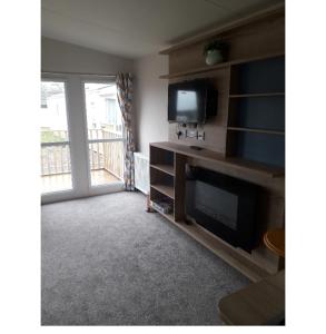 a living room with a television and a fireplace at Camelot Holiday Park, Longtown, Tranquility 21 Coworth in Carlisle