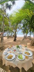 stół z talerzami jedzenia na plaży w obiekcie Golden Beach Paradise w Tangalli