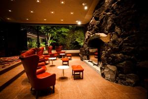 una sala de espera con sillas y una pared de piedra. en The Prince Karuizawa, en Karuizawa