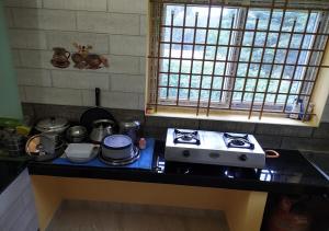 a kitchen with a stove and a counter top at Sun Deluxe Villa, Yercaud in Yercaud