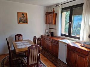 uma cozinha com uma mesa e cadeiras, uma mesa e uma janela em Ethno Village Štitarica em Mojkovac