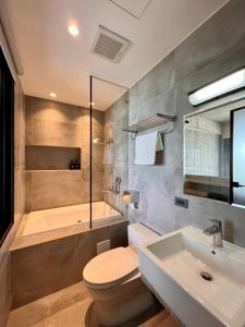 南灣的住宿－渥卡旅店，浴室配有卫生间、盥洗盆和浴缸。